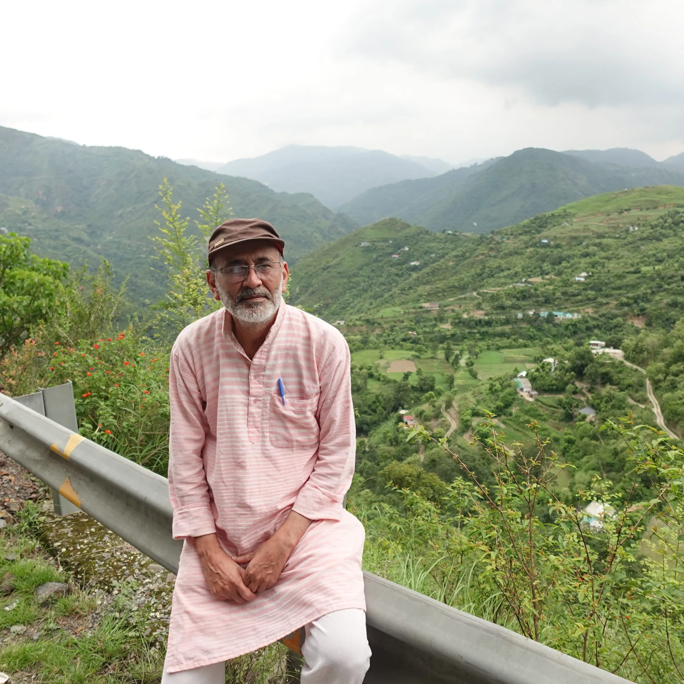 Pushpender Singh Gusain sitting by a mountain road